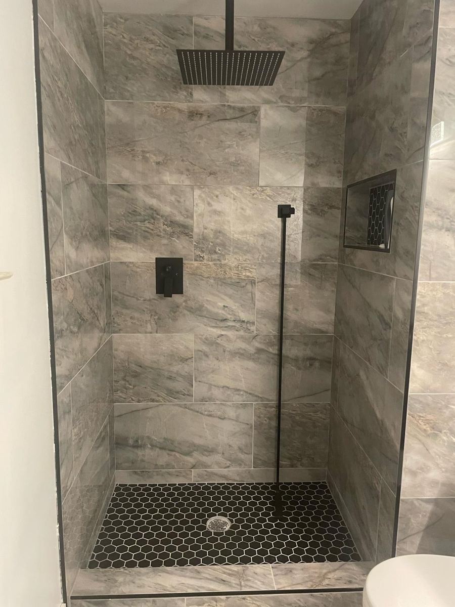 Finished gray marble shower with black hexagon floor and rain shower